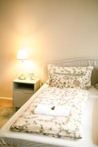 a bed with a white towel on it with a lamp at Kassel Rooms - Davinci Apartment in Kassel +10 photos