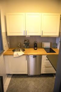 a kitchen with white cabinets and a sink at Kassel Rooms - Davinci Apartment in Kassel
