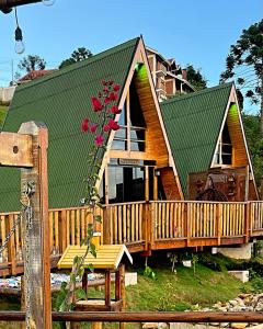 a large wooden house with a green roof at Chalés Laraland in Campos do Jordão +50 photos