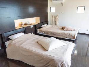 two beds in a room with two beds sidx sidx sidx sidx at Kaamlanai Harbor - Vacation STAY 48849v in Nichinan
