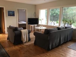 a living room with two couches and a table at 4 person holiday home in SKÅNES-FAGERHULT in Skånes Fagerhult
