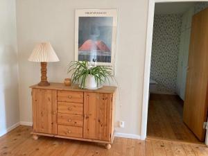a lamp on a wooden dresser in a room at 4 person holiday home in SKÅNES-FAGERHULT in Skånes Fagerhult