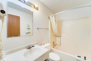 une salle de bain avec un lavabo, des toilettes et un miroir dans l'établissement Capital O Amerihost Inn and Suites Kingdom City Hwy 54 MO, à Kingdom City 54 autres photos