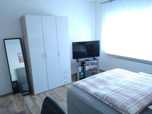 a bedroom with a bed and a flat screen tv at Jochen's House - Gästezimmer - Near Highway in Siershahn