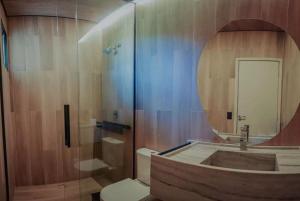 a bathroom with a shower and a toilet and a mirror at Morro dos Anjos Águas Quentes Hotel Resort in Bandeirantes +27 photos