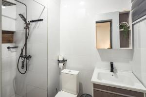 a bathroom with a shower and a toilet and a sink at Greyasset Amber in Spintex +2 photos