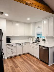 cocina con armarios blancos y suelo de madera en Enchanted Oaks Lakehouse, en Enchanted Oaks