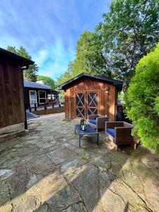 Un patio con un edificio con un banco y una mesa. en Enchanted Oaks Lakehouse, en Enchanted Oaks