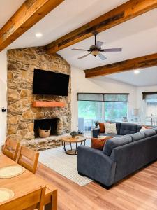 sala de estar con sofá y chimenea de piedra en Enchanted Oaks Lakehouse, en Enchanted Oaks