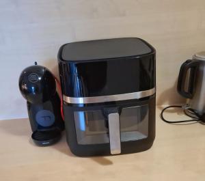 une cafetière noire posée sur un comptoir à côté d'une souris dans l'établissement Morska Ballada apartament 43m2 przy morzu, garaż, basen, sauny, à Jastrzębia Góra