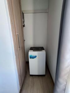 a small white refrigerator in a small room at Avana apartment in Flic-en-Flac