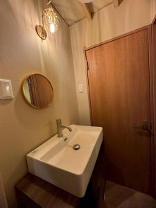 a bathroom with a white sink and a mirror at Fujimi no Oka Auto Campsite - Vacation STAY 27846v in Fuji