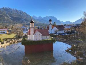 a small village with a church in the water at Ferienwohnung Soiernseelig in Wallgau