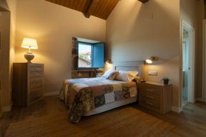 a bedroom with a bed and a dresser and a mirror at A Casa da Fonte Azul in Ourense +32 photos