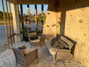 un porche avec un canapé et des chaises sur un patio dans l'établissement La Batisse, à Livron-sur-Drôme