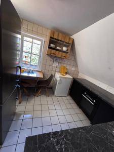a small kitchen with a table and a refrigerator at Dom gościnny przy Promenadzie in Świnoujście +27 photos