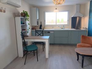 une cuisine avec une table et des chaises ainsi qu'une salle à manger dans l'établissement La Batisse, à Livron-sur-Drôme