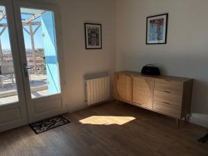 a room with a door and a dresser and a window at Bellis in Mortagne-sur-Gironde