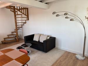 a living room with a black couch and a staircase at Bellis in Mortagne-sur-Gironde +10 photos