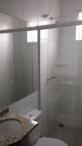 La salle de bains est pourvue de toilettes, d'un lavabo et d'une douche. dans l'établissement Hotel Araçari, à Araçariguama