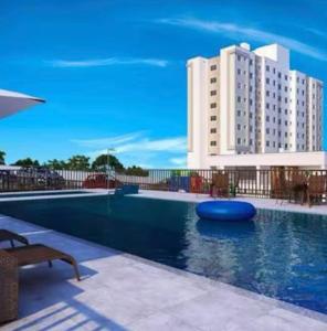 a swimming pool with a large building in the background at Seu Refúgio em São Luís MA in São Luís