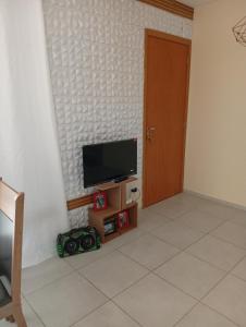 een kamer met een flatscreen-tv aan de muur bij Doce lar in Montes Claros +10 foto's