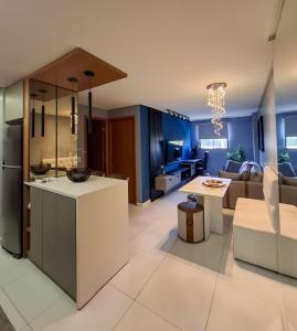 Una cocina y una sala de estar con un sofá y una mesa. en Smart Residence Praia, en Maceió