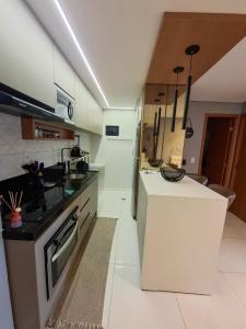 cocina con encimera, fregadero y fogones en Smart Residence Praia, en Maceió