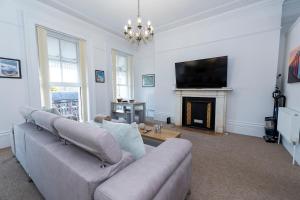 a living room with a couch and a flat screen tv at Spacious 2 Bed Apartment in Brighton- Free Parking in Brighton & Hove