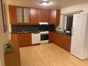 een keuken met houten kasten en een witte koelkast bij Tromsø Stay in Tromsø