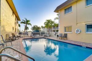 a swimming pool with chairs and a building at Near Beach! Modern Ground-Floor Condo in St Pete in St Pete Beach