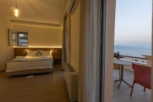 a bedroom with a bed and a view of the ocean at Ciel Residence in Nafpaktos
