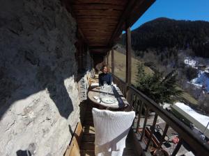 a person sitting at a table on a balcony at Arpege Des Neiges in Sainte-Foy-Tarentaise