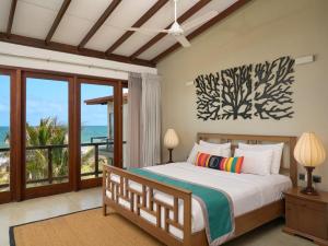 a bedroom with a bed with a view of the ocean at Driftwood Villa in Pamunugama