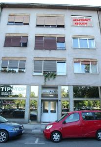 czerwony samochód zaparkowany przed budynkiem w obiekcie Apartment Keglich w Zagrzebiu