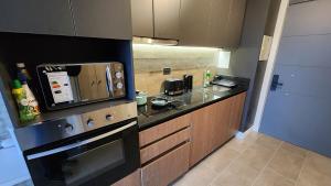 a kitchen with a stove and a microwave at Departamento Estudio, ubicación inmejorable, con estacionamiento in Los Ángeles
