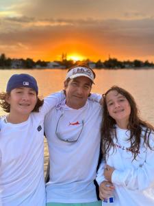a man and two children posing for a picture on the beach at V3 Pr Rentals Walk To The Beach 7 Min in San Juan