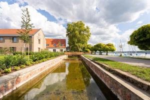 a canal in front of a building next to a building at Patrikabin in Tata