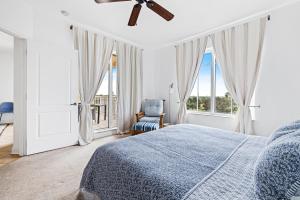 a bedroom with a bed and a chair and windows at Spacious Gated Minorca Retreat, Pet Friendly with Pond Views and Resort Amenities - MM403 in Isleboro +41 photos