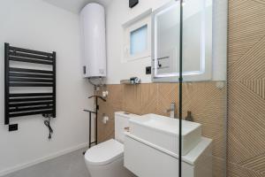 a bathroom with a toilet and a sink and a window at Patrikabin in Tata +29 photos