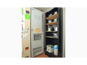 a refrigerator in a kitchen next to a shelf at Smile Hotel Otsu Seta - Vacation STAY 00128v in Zeze-Awazumachi