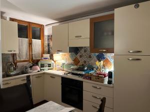 eine Küche mit weißen Schränken und einem Herd mit Backofen in der Unterkunft Casa di Zara in Venedig