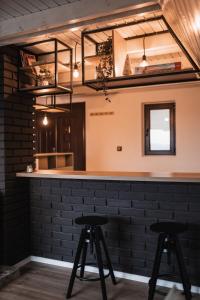 Una barra con dos taburetes frente a una pared de ladrillos. en Forrest House, en Doboj