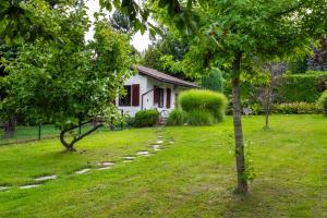 a small white house in a yard with trees at Sielankowy domek w górach in Bielsko-Biala