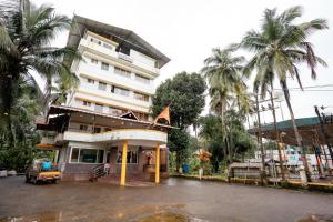 a building with palm trees in front of it at Kukke Sai Skanda in Subrahmanya