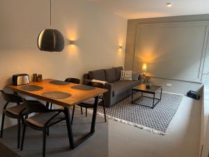 a living room with a table and a couch at Cozy apartment in new building in Hamburg