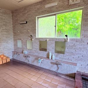 a bathroom with three mirrors on a brick wall at Minpaku Gozamisaki - Vacation STAY 23480v in Goza