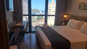 a hotel room with a bed and a large window at MHFA - Studios em Prédio Luxuoso com Vista Mar in Itapema +141 photos