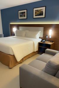 ベレンにあるHoliday Inn Express Belem Ananindeua by IHGの大きな白いベッドとソファのある寝室