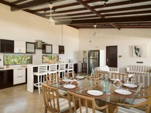 a kitchen and dining room with a table and chairs at Driftwood Villa in Pamunugama